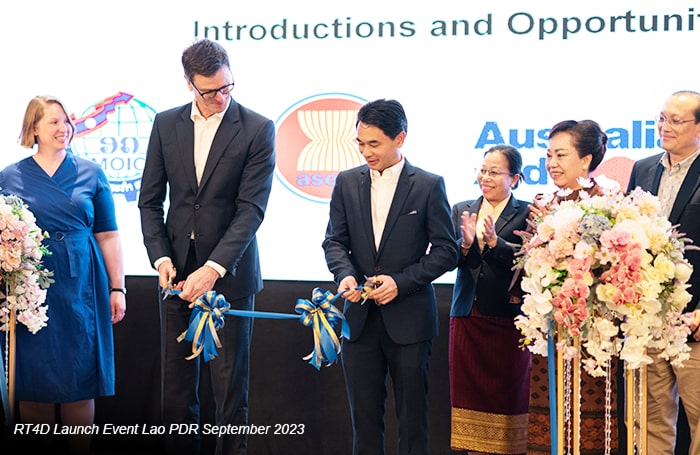 A group of men and women cutting a ribbon at an event 