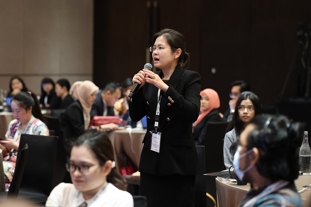A female with a microphone asking a question at a conference